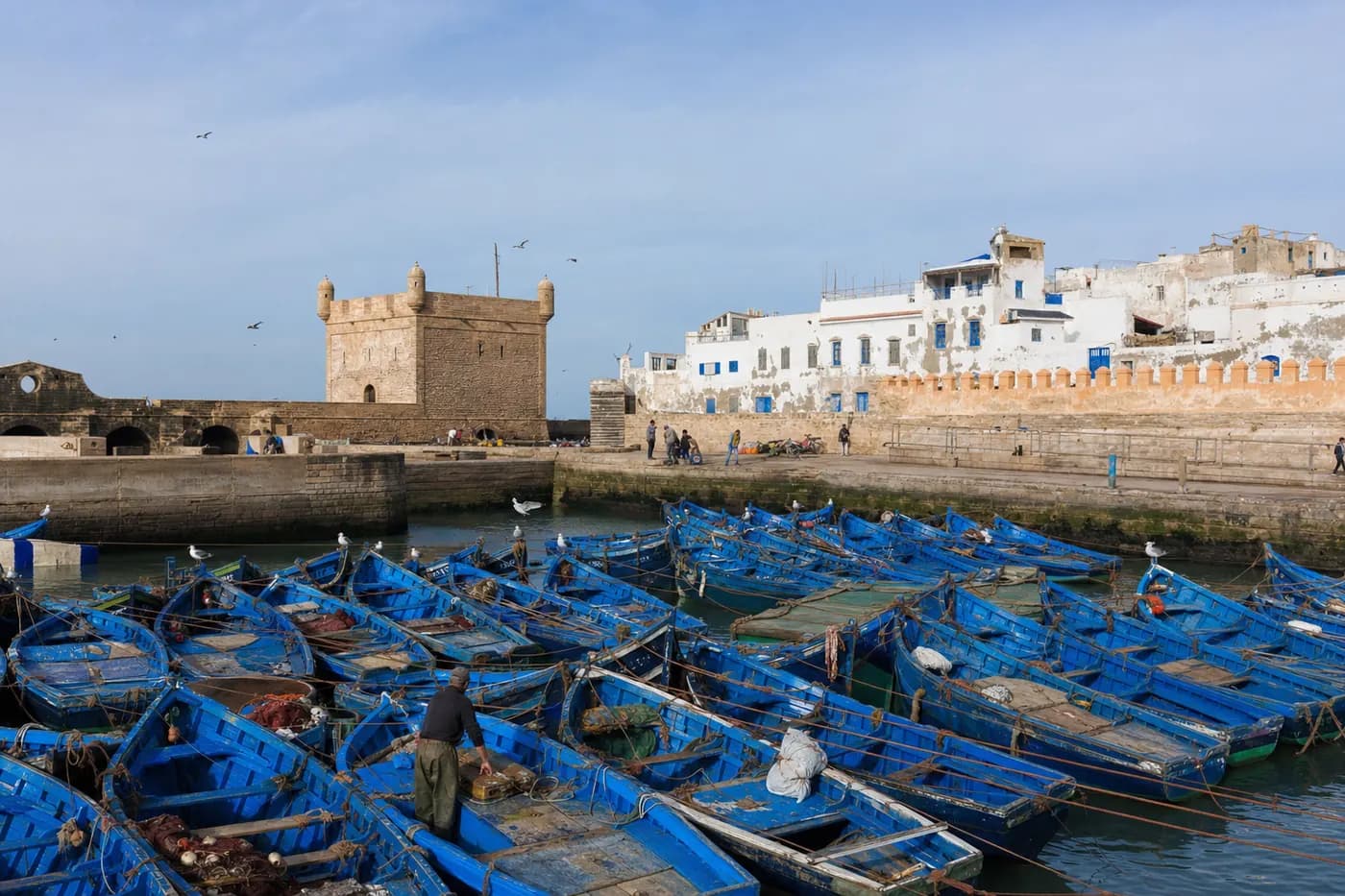 Blue fishing boats in Essaouira harbour below the ramparts